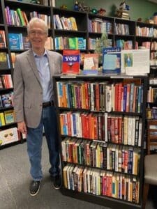 Tom standing with books